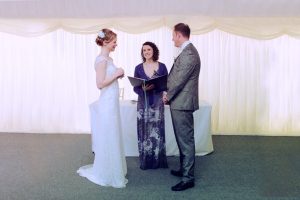 A Bride and Groom stand in front of their Celebrant Keli Tomlin and speak their vows