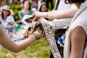 Hands are bound in handfasting by a black and white belt. Part of a four part handfasting by Keli Tomlin Ceremonies