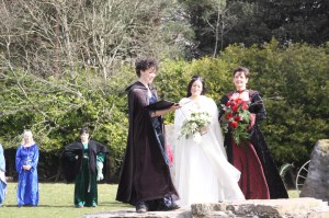 Pagan Celebrant Keli Tomlin officiates over the wedding of two brides in medieval dress in the Stone Circle at Ruthin Castle.